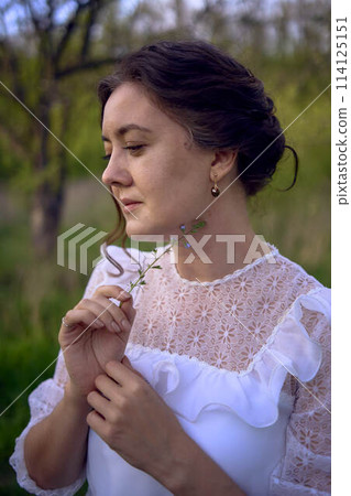 beautiful woman in white vintage dress with train in spring garden at sunset beautiful woman in white vintage dress with train in spring garden at sunset 114125151