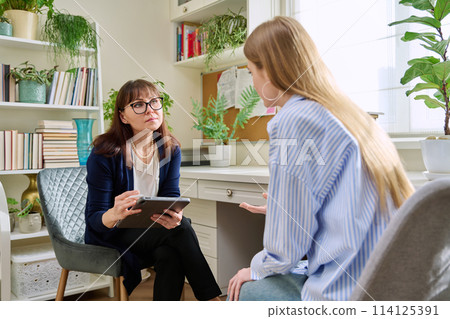 Female psychologist having therapy session with young woman Female psychologist having therapy session with young woman 114125391