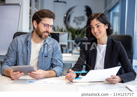 Colleagues working in collaborative office environment Colleagues working in collaborative office environment 114125757