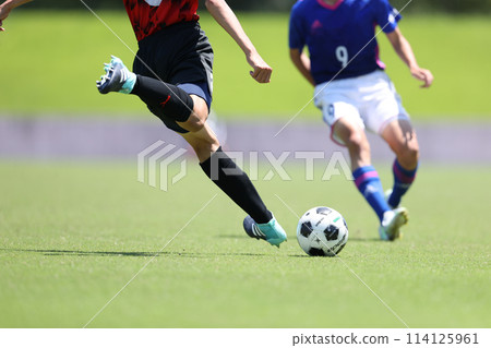 A player dribbling in a soccer match A player dribbling in a soccer match 114125961