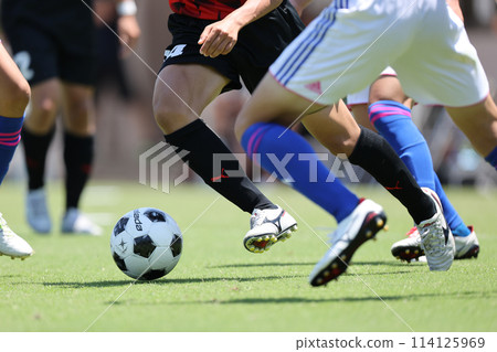 A player dribbling in a soccer match 114125969