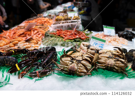 Fresh lobster, shrimps, crabs, sea urchin and other seafood on market counter. Food stalls at La Boqueria market in Barcelona Fresh lobster, shrimps, crabs, sea urchin and other seafood on market counter. Food stalls at La Boqueria market in Barcelona 114126032