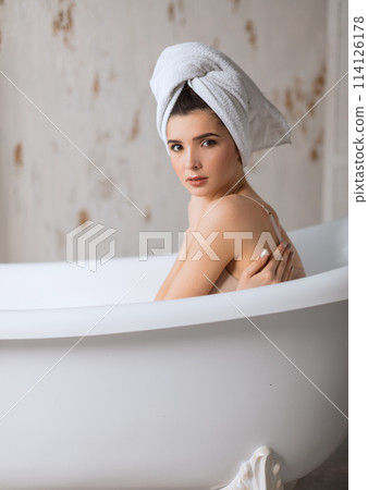 Relaxed young woman laying in bathtub Relaxed young woman laying in bathtub 114126178