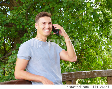 Man using mobile phone outdoors 114126631