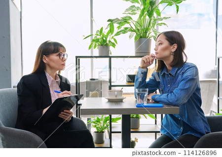 Young female patient at therapy meeting with psychologist, mental therapist 114126896
