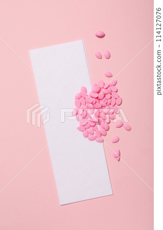 Wax granules for depilation on a pink background Wax granules for depilation on a pink background 114127076
