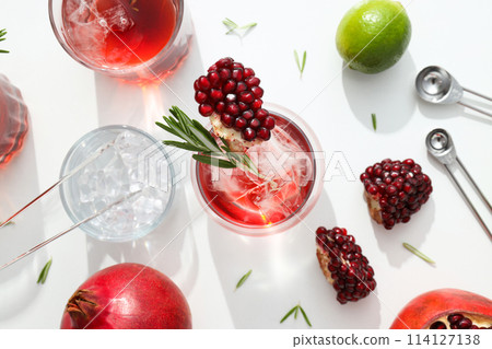 Red cocktail with fresh pomegranate and lime on a white background 114127138