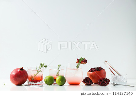 Red cocktail with fresh pomegranate and lime on a white background 114127140