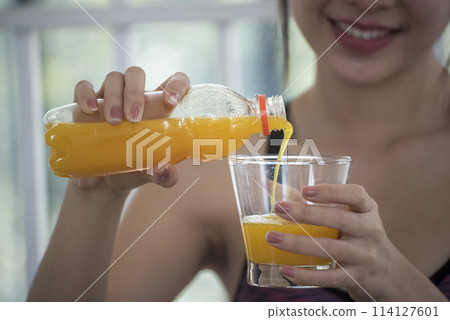 Asian women smile laugh look at camera health care home fitness lifestyle. Women hands holding cold orange juice fresh fruit cool drinking. Beautiful female pouring orange juice from cocktail bottle Asian women smile laugh look at camera health care home fitness lifestyle. Women hands holding cold orange juice fresh fruit cool drinking. Beautiful female pouring orange juice from cocktail bottle 114127601