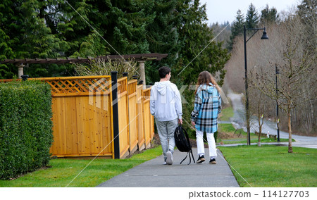 Young man and woman walking together on street in nature on sunny day 114127703