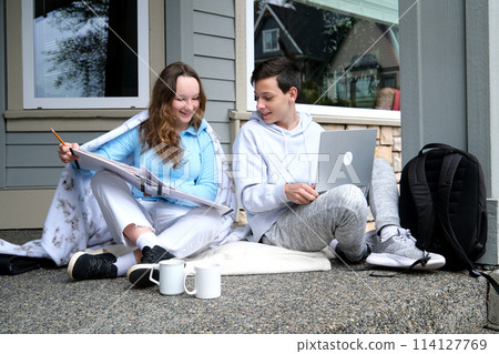do homework together peep boy and girl sit next in tracksuits and plaid girl smiles turns boy helps finds mistakes straightens hair desire likes help friend School years Classmates teenagers do homework together peep boy and girl sit next in tracksuits and plaid girl smiles turns boy helps finds mistakes straightens hair desire likes help friend School years Classmates teenagers 114127769