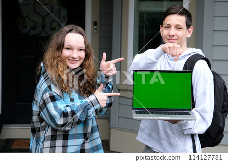 Boy and girl with blank advertising board laptop screen chromakey girl showing fingers with two hands guy advertises holding a backpack schoolchildren teenagers friends Boy and girl with blank advertising board laptop screen chromakey girl showing fingers with two hands guy advertises holding a backpack schoolchildren teenagers friends 114127781