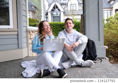 sincere loud laughter boys girl watching movie internet online laughing out loud modesty girl holding a laptop on her knees next to a briefcase private sector Healthy children beautiful nation sincere loud laughter boys girl watching movie internet online laughing out loud modesty girl holding a laptop on her knees next to a briefcase private sector Healthy children beautiful nation 114127791