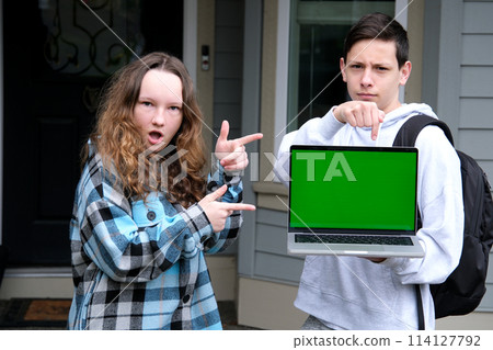 Happy man and woman showing laptop and pointing 114127792