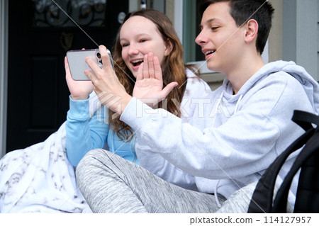 Beautiful young couple relaxing on a couch at home, using laptop computer, taking a selfie Beautiful young couple relaxing on a couch at home, using laptop computer, taking a selfie 114127957