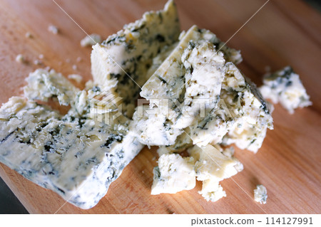 Rotation cheese on black slate plate. Delicious cheese Dorblu on the cutting board on background 114127991