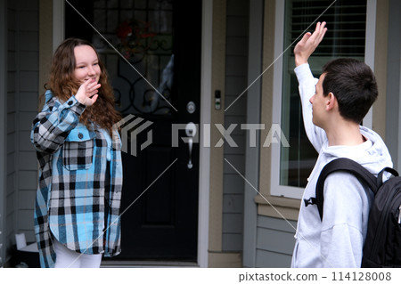 Young people, man and woman greeting or saying goodbye by waving hands in the park. Young people, man and woman greeting or saying goodbye by waving hands in the park. 114128008