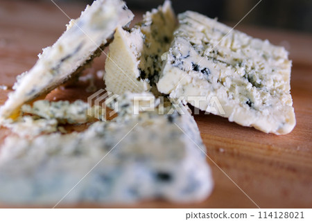 Rotation cheese on black slate plate. Delicious cheese Dorblu on the cutting board on background Rotation cheese on black slate plate. Delicious cheese Dorblu on the cutting board on background 114128021