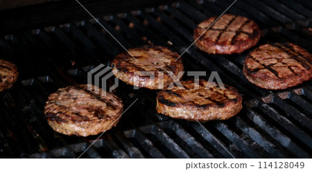 Hamburgers cooling on flaming grill, slow motion. Shot on Phantom Flex 4K camera. 114128049