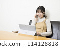 A woman making a phone call while using a laptop 114128818