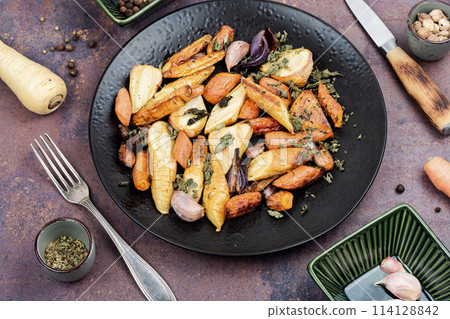 Baked sliced parsnip root and carrots. 114128842