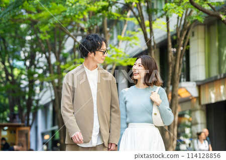 微笑著在城裡散步的年輕夫婦 114128856