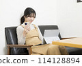 Young woman using a laptop and smartphone 114128894