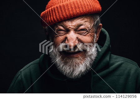 Happy 70-year-old optimist man with smiling wrinkled face, isolated on dark Happy 70-year-old optimist man with smiling wrinkled face, isolated on dark 114129056
