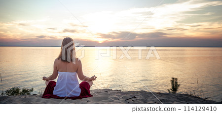 Woman meditating at the sea 114129410