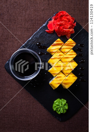 Sushi set with soy sauce and wasabi on black stone plate. Delicious and fresh Japanese cuisine. Perfect for a meal or snack. Sushi set with soy sauce and wasabi on black stone plate. Delicious and fresh Japanese cuisine. Perfect for a meal or snack. 114130419