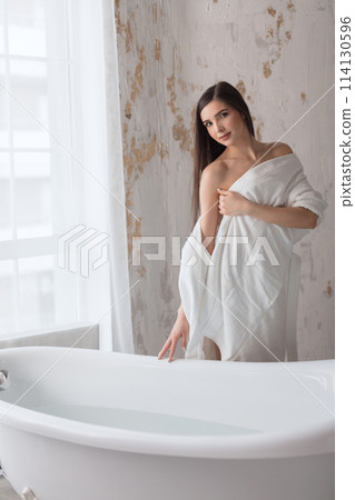 Beautiful young brunette woman posing in a bathrobe Beautiful young brunette woman posing in a bathrobe 114130596
