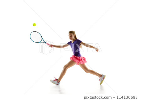 Focused on game young girl, tennis player in vibrant uniform ready to serve ball to opponent against white studio background. 114130685