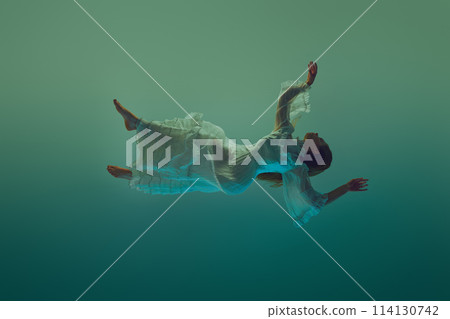 Young woman in dynamic pose, her dress fanning out beautifully in water environment against serene aqua background. 114130742