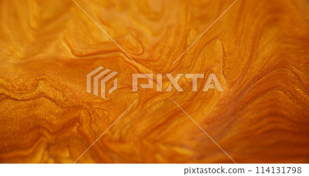 Liquid glitter. Shiny paint texture. Defocused golden color sparkling metallic sand particles glow acrylic gloss ink emulsion fluid spill abstract art background. 114131798