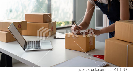 Woman in an online store check the customer address and package information on box. Online shopping concept 114131921
