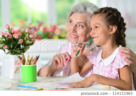 Portrait of a cute little girl drawing with her grandmother Portrait of a cute little girl drawing with her grandmother 114131965