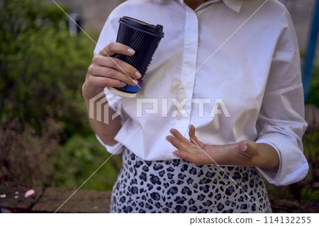 middle age woman in 70s, 80s style clothes spilled coffee on herself during a break outside 114132255