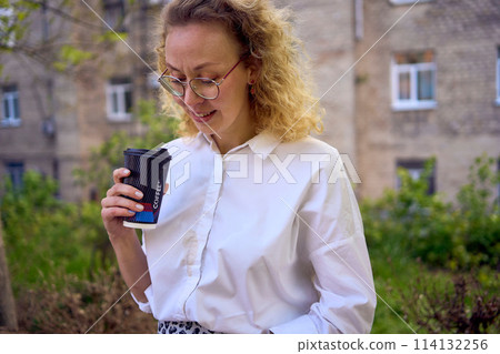 middle age woman in 70s, 80s style clothes spilled coffee on herself during a break outside 114132256