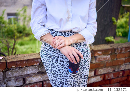 middle age woman in 70s, 80s style clothes with a coffee stain on her blouse in front of gray houses of the 70s middle age woman in 70s, 80s style clothes with a coffee stain on her blouse in front of gray houses of the 70s 114132271