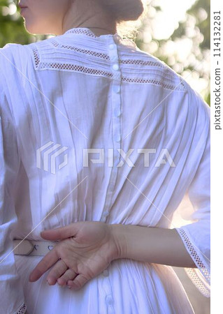 chic middle aged woman in a white vintage dress, details of the outfit chic middle aged woman in a white vintage dress, details of the outfit 114132281
