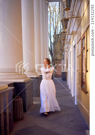 elegant middle age woman in white vintage dress near theater with antique colonnades elegant middle age woman in white vintage dress near theater with antique colonnades 114132295