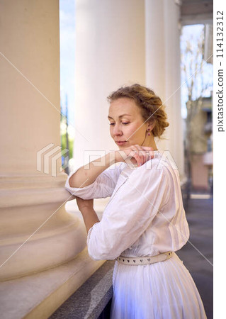 elegant middle age woman in white vintage dress near theater with antique colonnades elegant middle age woman in white vintage dress near theater with antique colonnades 114132312