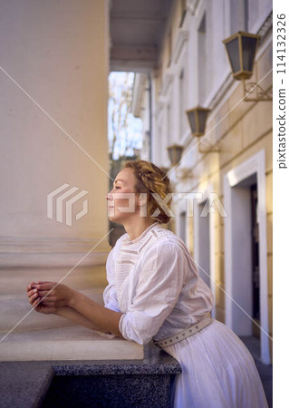 elegant middle age woman in white vintage dress near theater with antique colonnades elegant middle age woman in white vintage dress near theater with antique colonnades 114132326