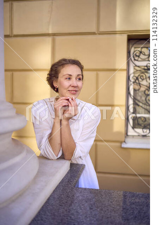 elegant middle age woman in white vintage dress near theater with antique colonnades elegant middle age woman in white vintage dress near theater with antique colonnades 114132329