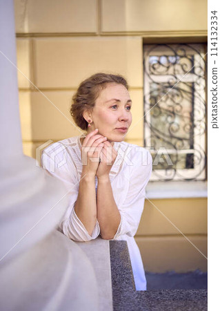 elegant middle age woman in white vintage dress near theater with antique colonnades elegant middle age woman in white vintage dress near theater with antique colonnades 114132334