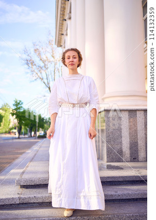 elegant middle age woman in white vintage dress near theater with antique colonnades elegant middle age woman in white vintage dress near theater with antique colonnades 114132359