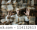 A man in the library shows his palms and a lot of books 114132613