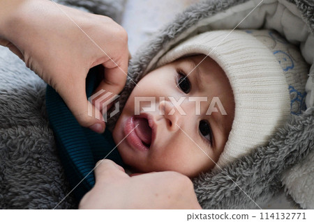 A mother dressing her little baby boy boy at home. childhood parenthood and growing up family concept real people A mother dressing her little baby boy boy at home. childhood parenthood and growing up family concept real people 114132771