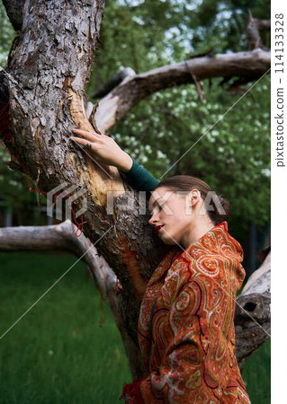 Slavic girl in a scarf with dead tree 114133328