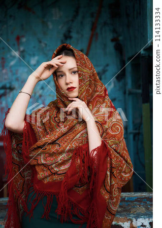 Slavic girl in a scarf on blue background Slavic girl in a scarf on blue background 114133334